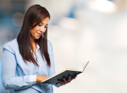 Szczęśliwa młoda kobieta z książką