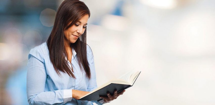 Szczęśliwa młoda kobieta z książką